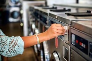Woman Putting a Quarter in a Laundry Machine