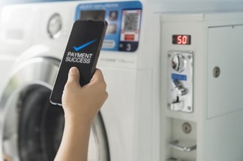 Close-up of Smartphone Showing Payment Success in Laundry Room